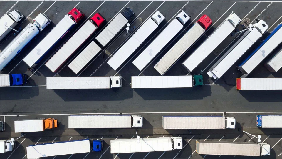 Luftaufnahme eines Parkplatzes an der A45 bei Freudenberg, auf dem zahlreiche Lastwagen geparkt haben, fotografiert von Arnulf Stoffel.