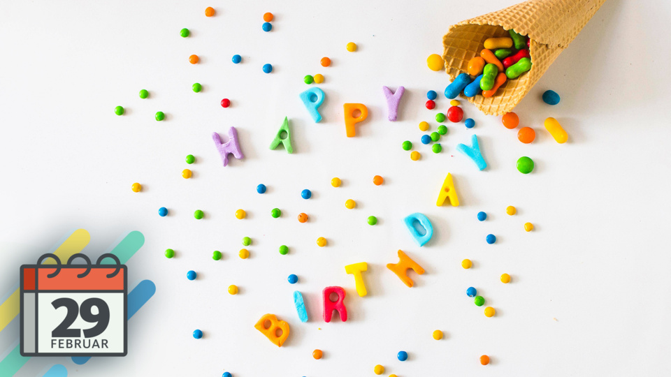 "Happy Birthday" in bunten Buchstaben neben Süßigkeiten